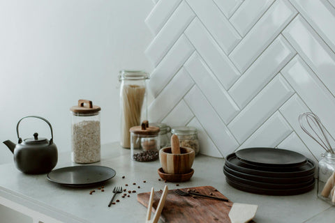 A well-organized kitchen counter with jars, utensils, and dishware in a modern setting.