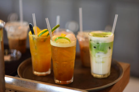 A variety of iced drinks including tea and matcha latte served on a tray, perfect for cooling down.