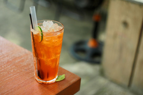 Chilled glass of iced tea with lime on a sunny day. Perfect for summer vibes.