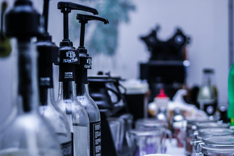 Stylish coffee shop syrups lined up with pumps, captured in Indonesia. Perfect for urban lifestyle scenes.