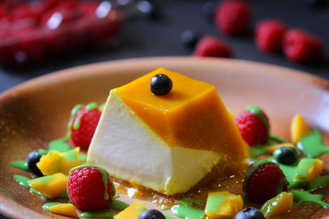 A delicious panna cotta topped with fresh fruits and vibrant sauces, perfect for dessert lovers.