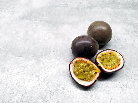 Juicy ripe passion fruits on a flat, stone-textured surface. Perfect for food photography.